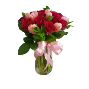 red roses and pink tulips in a glass vase